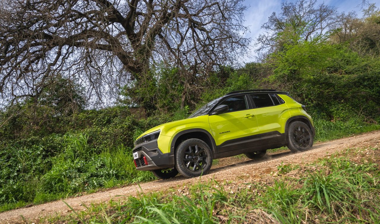 Zeleni Jeep Avenger 4xe med vožnjo po makadamski poti